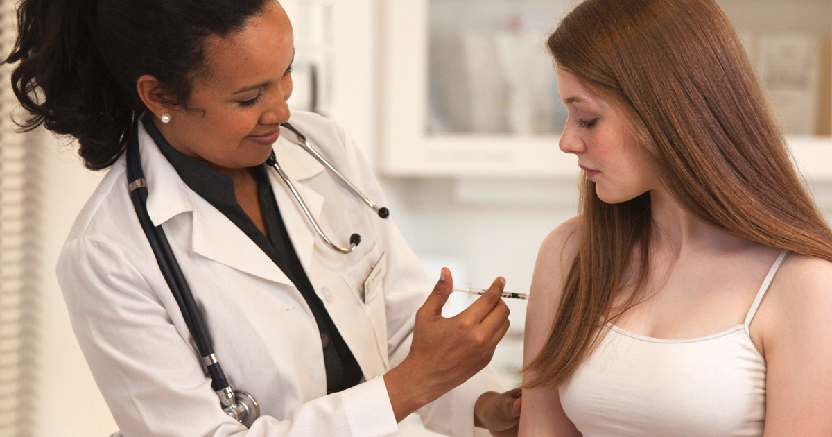 Woman doctor administering a HPV vaccine to a young woman.