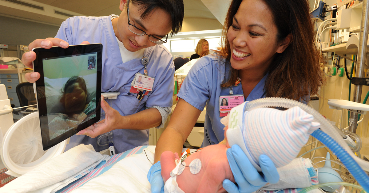 Nurses Julius Caceres, left, and Yvonne Kidder, help a mother using BabyTime.