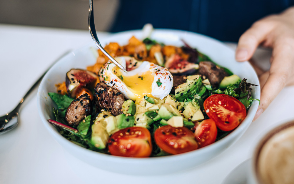 Bowl of salad with an egg on top